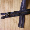 open-ended metal zip antique brass teeth color , single zip on a wooden table