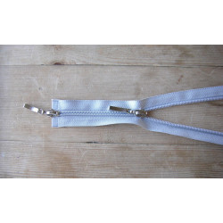 double slider zip - light grey - 50cm, placed on a wooden background, close up on the zip sliders