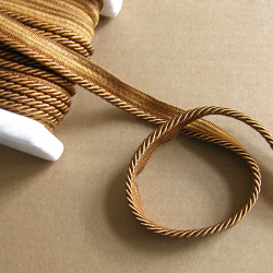 Flanged piping cord  in bronze color, 5mm wide piping , full reel on the table