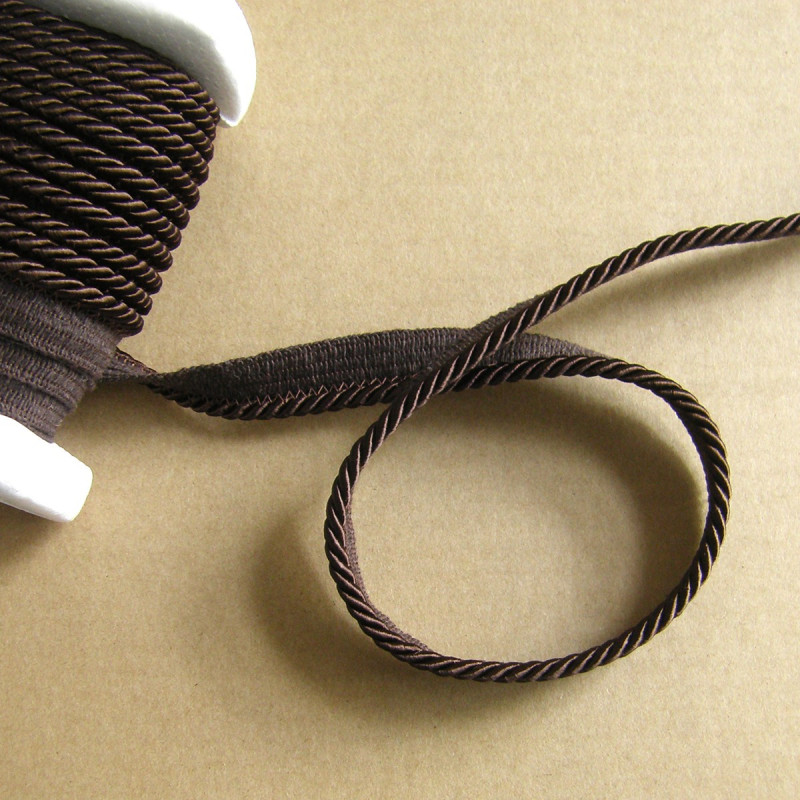 Flanged piping cord  in dark brown color, 5mm wide piping , full reel on the table