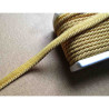Twisted flanged piping cord 7mm wide in gold color on beige table
