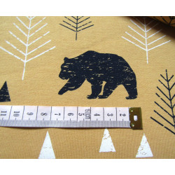 Sweatshirt jersey fabric -  FOREST on mustard background close up of the pattern with measuring tape