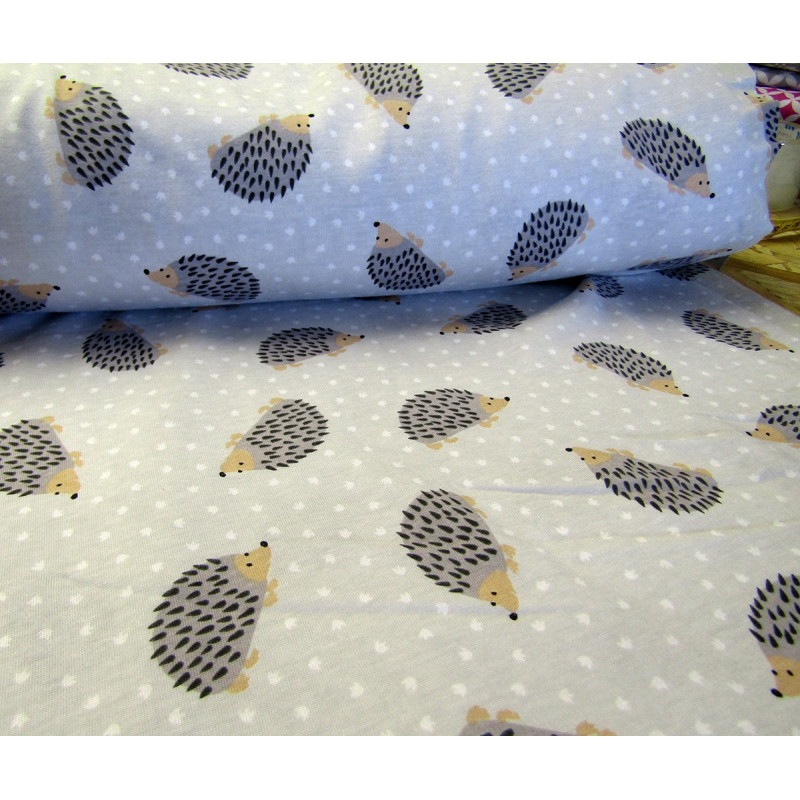 Cotton interlock jersey - Hedgehogs on light grey, the fabric from the roll across the table