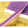 Twisted flanged piping cord 7mm wide in intense lilac color from the reel on wooden background