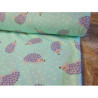 Cotton interlock jersey - Hedgehogs on mint, the fabric from the roll across the table