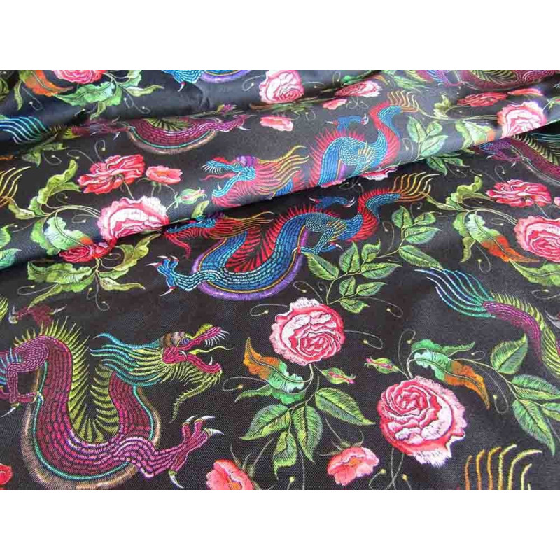 Water-resistant canvas fabric - Dragons&Roses on black placed across the frame with a fold