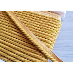 Upholstery piping cord 10mm - ochre color, full reel, on wooden background