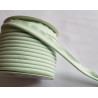 A full reel of plain, light green flanged piping cord on white background