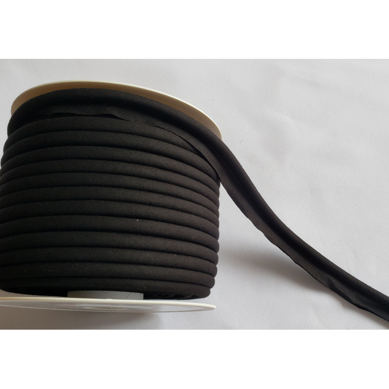 A full reel of plain, black flanged piping cord on white background