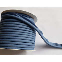 A full reel of plain, denim blue flanged piping cord on white background