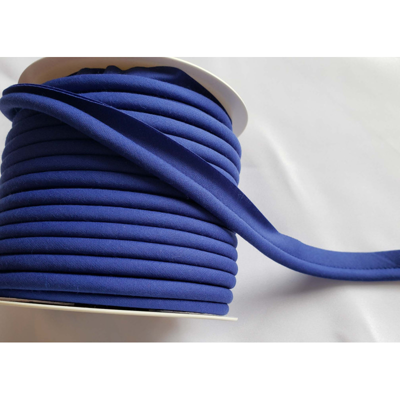 A full reel of plain, royal blue flanged piping cord on white background