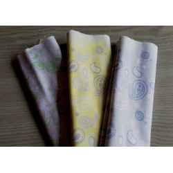 Cotton fabric remnants bundle , paisleys pattern in different colors, placed on grey table