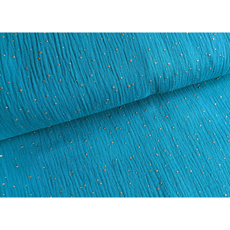 Double gauze fabric with gold speckles - 100% cotton fabric in intense sea blue color across the table