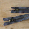 Open-ended metal zip in  dark grey, color, 50cm long - Antique brass, two zips on the wooden table