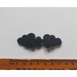 Chinese frog fastener in black color on a white background with the ruler