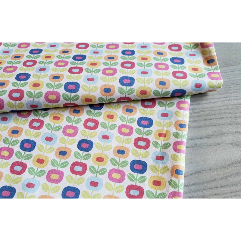 Multiflower white -medium-weight cotton with Scandinavian-style small flowers, the fabric folded on a grey table