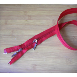 plastic double slider zip - red color -90cm long on a wooden background