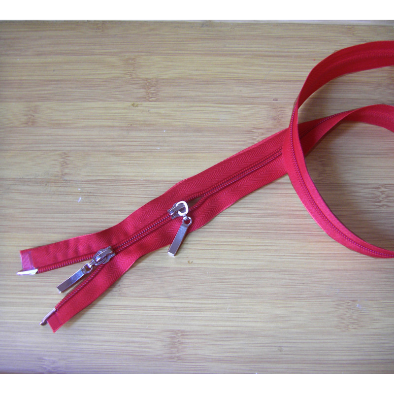 plastic double slider zip - red color -90cm long on a wooden background