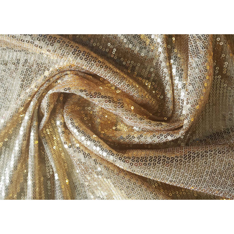 flexible sequin fabric- gold color, the fabric twisted into a swirl