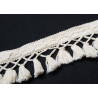 Cotton tassels- fringe - natural color, on a black background, placed across the shot