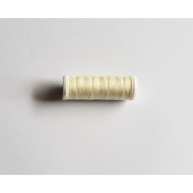 Sewing machine thread - light cream color - 200m spool, placed on a white background