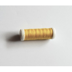 Sewing machine thread - dark yellow color - 200m spool, placed on a white background
