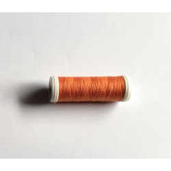 Sewing machine thread - dark orange color - 200m spool, placed on a white background