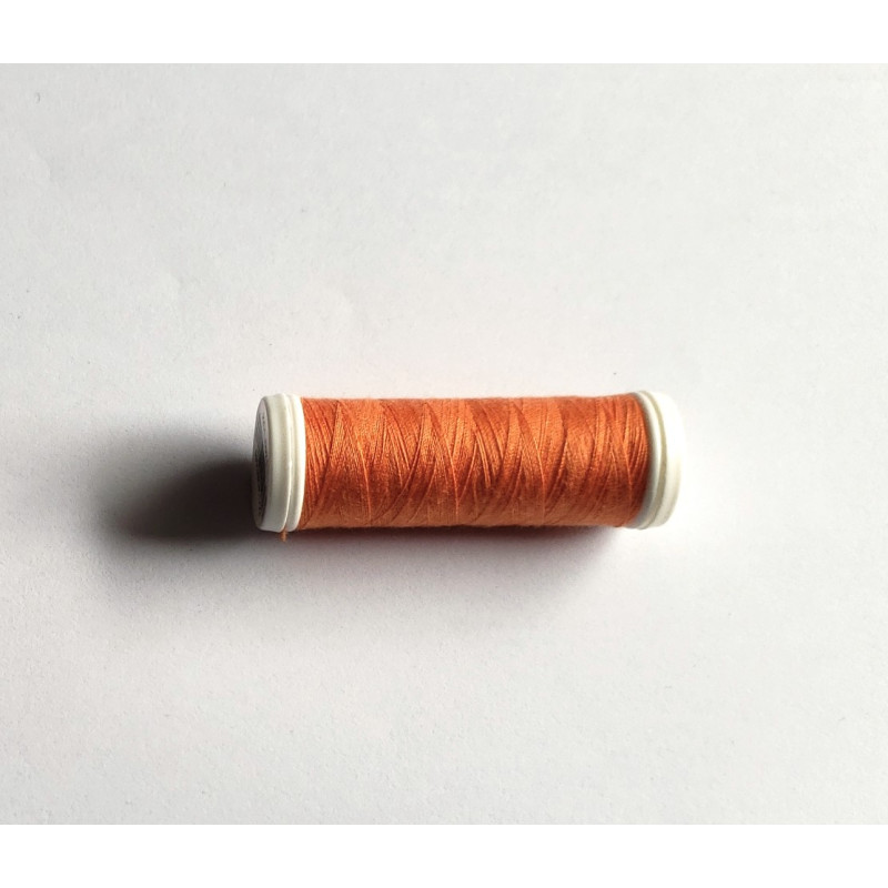 Sewing machine thread - dark orange color - 200m spool, placed on a white background