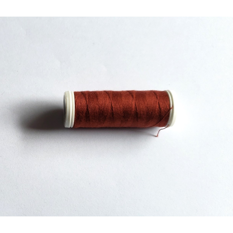 Sewing machine thread - maroon color - 200m spool, placed on a white background