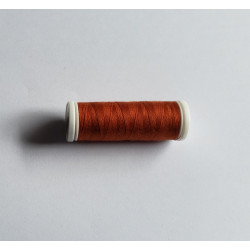 Sewing machine thread - burnt orange color - 200m spool, placed on a white background