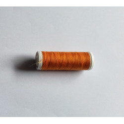 Sewing machine thread - deep orange color - 200m spool, placed on a white background