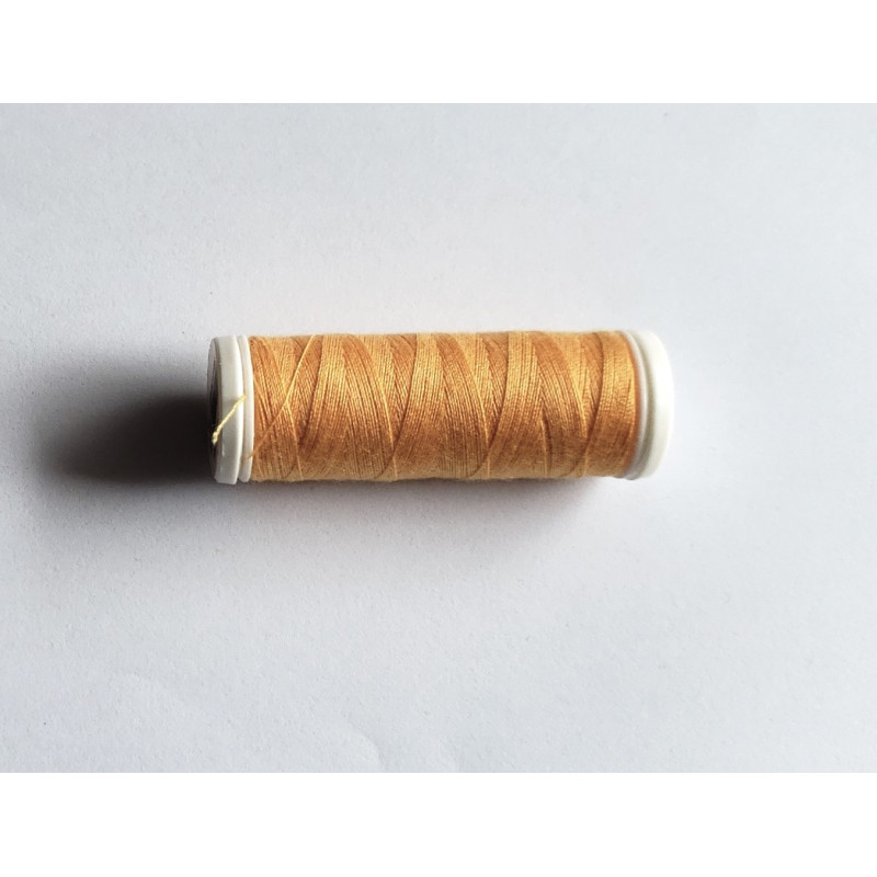 Sewing machine thread -light orange color - 200m spool, placed on a white background