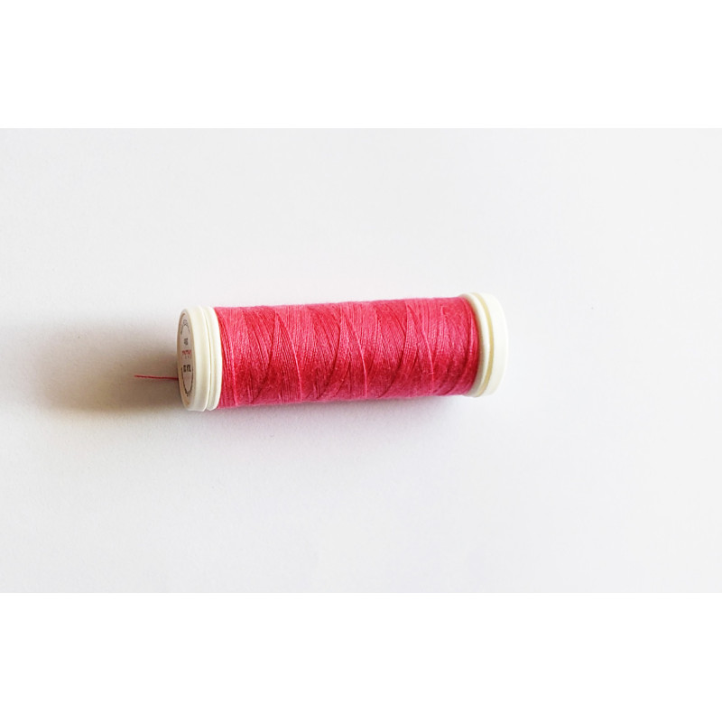 Sewing machine thread - intense pink color - 200m spool, placed on a white background