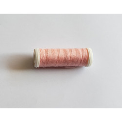 Sewing machine thread - peach pink color - 200m spool, placed on a white background