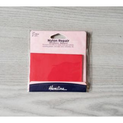 Nylon Repair Patch - self-adhesive - RED placed on a grey table
