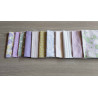 Jelly roll pre cuts bundle - sage/lilac mood two bundle sizes, full set of fabrics placed on a grey table