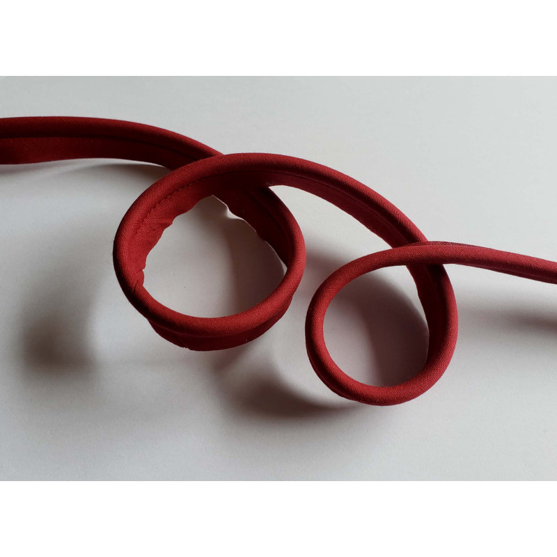 Plain, burgundy flanged piping cord on a white background