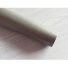 Self-Adhesive Faux leather fabric - darker grey, the roll of the fabric placed across the grey table