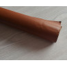 Self-Adhesive Faux leather fabric - chestnut, the roll of the fabric placed across the grey table