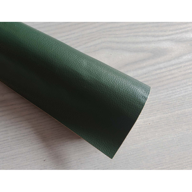 Self-Adhesive Faux leather fabric - dark green, the roll of the fabric placed across the grey table