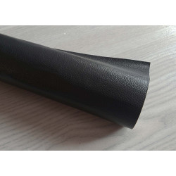 Self-Adhesive Faux leather fabric - black, the roll of the fabric placed across the grey table