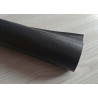 Self-Adhesive Faux leather fabric - black, the roll of the fabric placed across the grey table