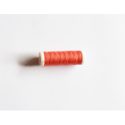 Sewing machine thread - coral orange color - 200m spool, placed on a white background