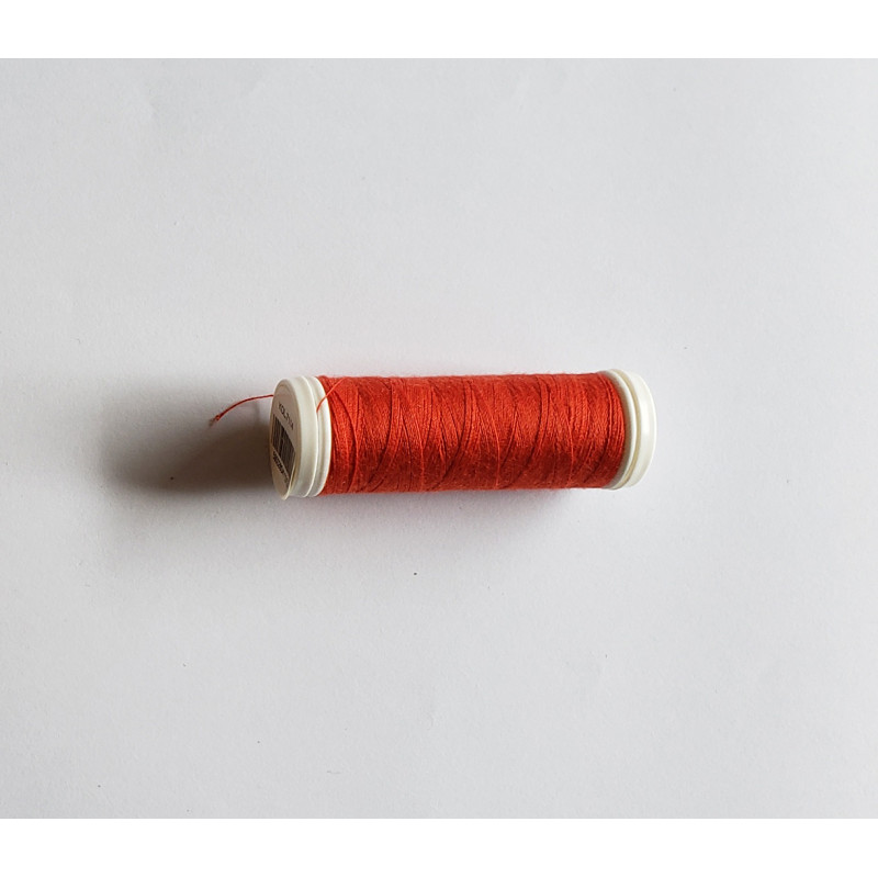 Sewing machine thread -  dark orange red color - 200m spool, placed on a white background