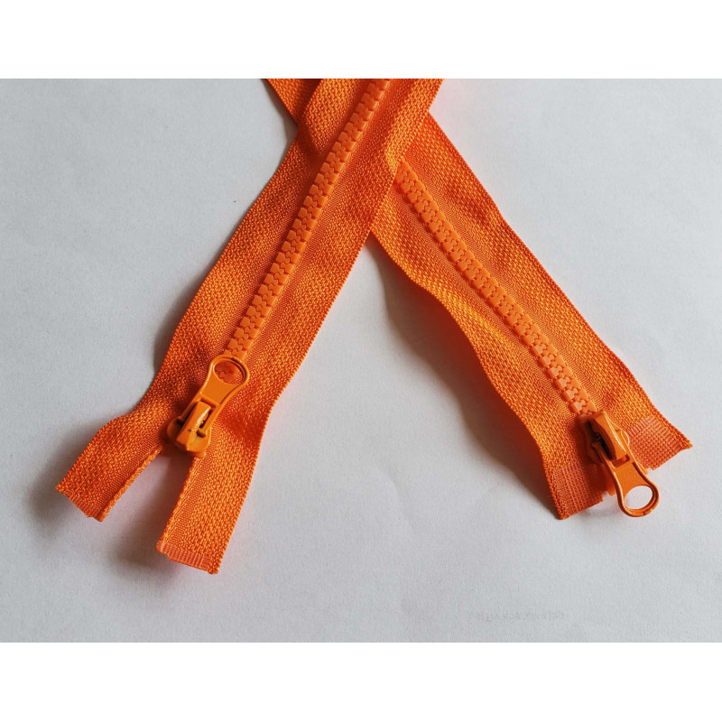 double slider zip - orange color - chunky type - 90cm long, placed on a grey table