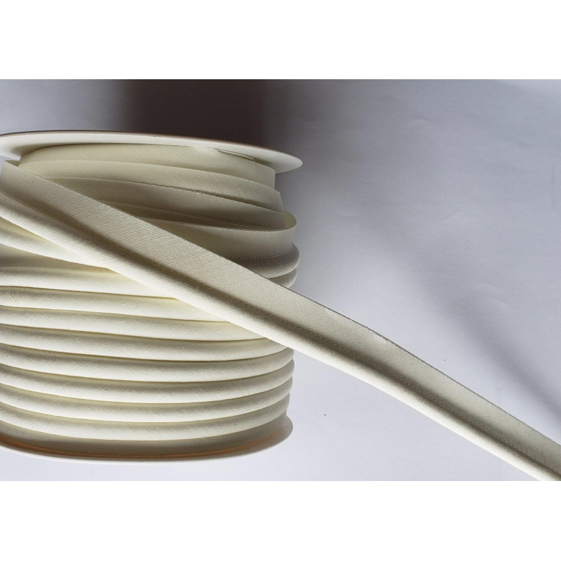 A full reel of plain, cream flanged piping cord on white background