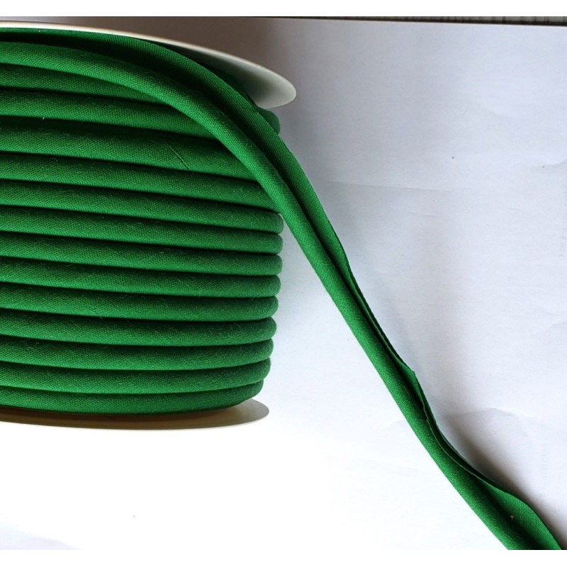 A full reel of plain, apple green flanged piping cord on white background