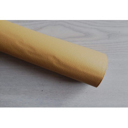 Self-Adhesive Faux leather fabric - caramel, the roll of the fabric placed across the grey table