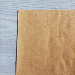 Self-Adhesive Faux leather fabric - caramel, the sheet of the fabric placed on a grey table, close up