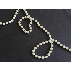 round pearl trim - ivory  twisted on a black background